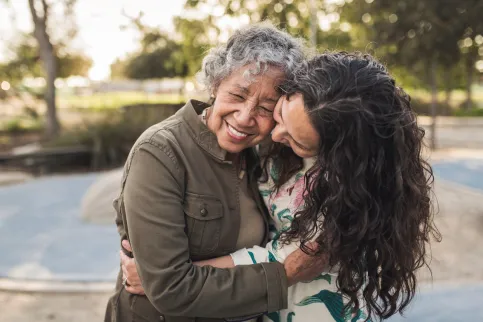 Young woman hugging an older woman, symbolising the different needs for different generations with respect to cancer