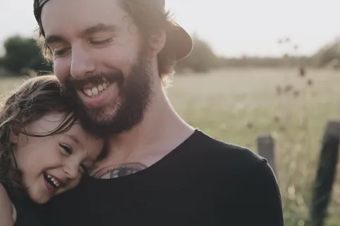 Father and daughter laughing in the sun