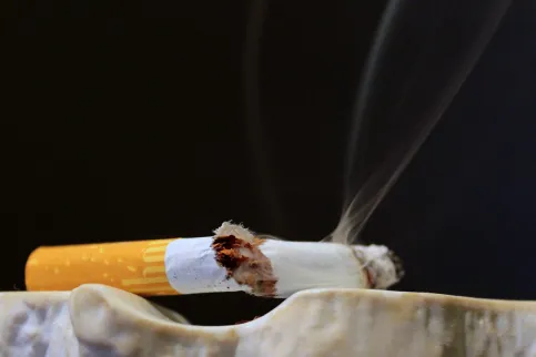 Broken cigarette resting on ashtray to symbolise smoking as a risk factor for many diseases including cancer and the benefits of quitting