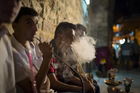 Men smoking waterpipes outside in the evening