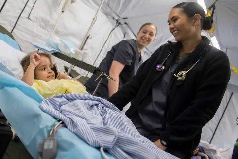 Grace Romasko with a 4-year old Honduran girl in the expeditionary medical unit in Puerto Cortes, Honduras, during the US operation "Continuing Promise" in 2018. Photo by Mike DiMestico.
