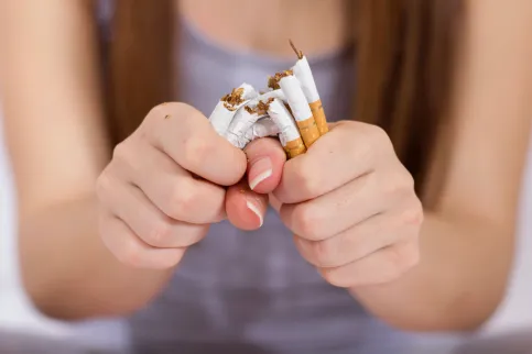 Woman breaking a handful of cigarettes