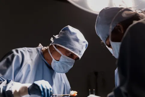 Image shows surgeon at work, emphasising the importance of comprehensive healthcare on in cancer control
