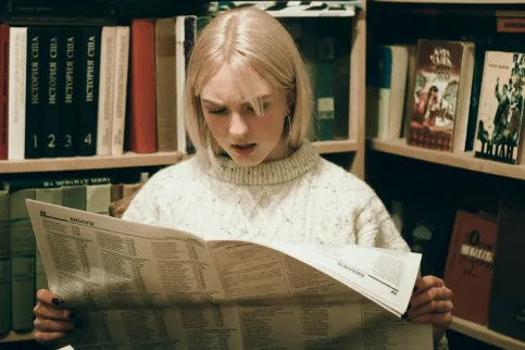 Women reading newspaper with an astonished Face