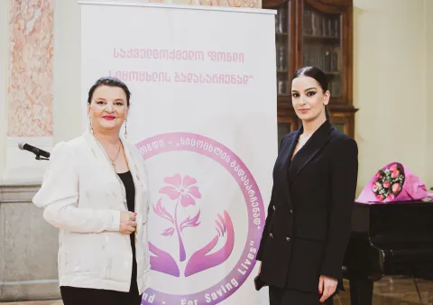 Photo of two women in front of a pull-up banner