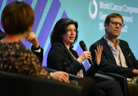 Female speaker with female panelist on her right and male panelist on her left