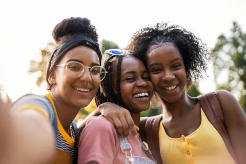 Three young girls hugging and smiling