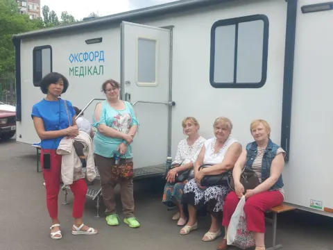 Family in Ukraine in front of a medical mobile platform established by the Charitable Fund ‘Kvitna’