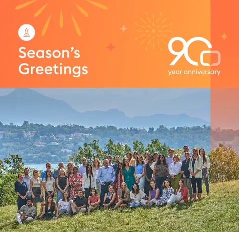 UICC branded Season's greeting card with UICC Geneva staff posing in front of the lake