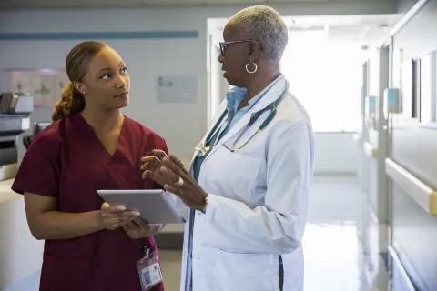 Two Black women health practitioners speaking