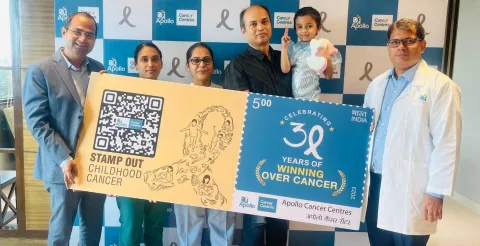 Apollo Hospital staff holding up a large banner celebrating 30 years of addressing cancer