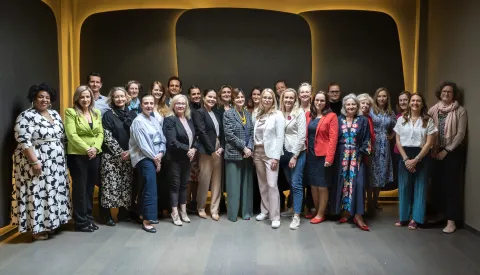 Diverse group of people standing in rows on a staircase, the TNM Core Committee