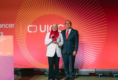 A photo of Hanaa Serry holding the World Cancer Day Award standing next to Jeff Dunn, UICC President at the World Cancer Congress 2024