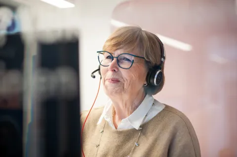 Older woman with a headset answering a call