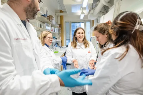 Group of young health practitioners or researchers in white overcoats