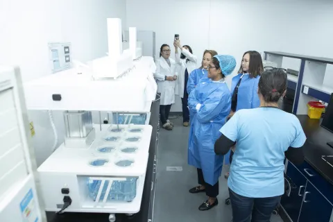 Group of women in lab blouses examining samples