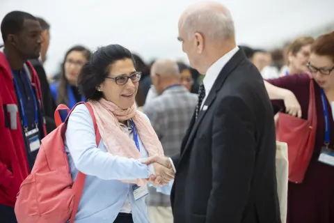 Women shaking hands with older man