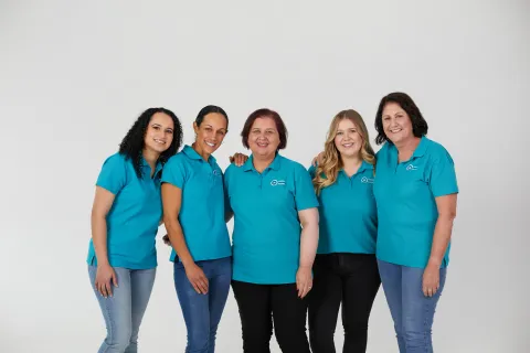 Diverse group of five women wearing turquoise branded shirts for Ovarian Cancer Australia