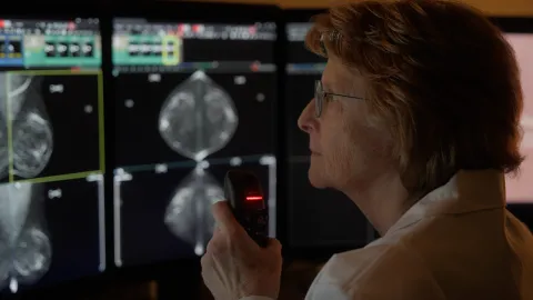 Woman looking an AI analysis of a breast cancer scan