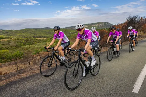 Cyclists wearing pink and white jerseys