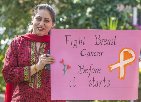 Woman at a breast cancer awareness campaign in Pakistan holding up a signpost that says: "Fight breast cancer before it starts". Photo by UICC is offering grants to members for projects aimed at improving access to early detection. Photo by Salman Asif/UN Women Asia and the Pacific,  breast cancer awareness campaign in Pakistan in 2013.