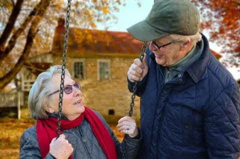 there continues to be a lack of awareness about this issue of cancer in older adults and few investments in the health services required to respond to the unique needs of this group Elderly woman on a swing looking up at an elderly man