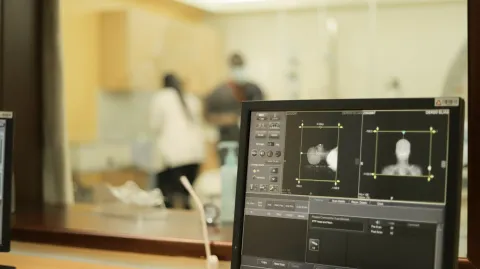 Close up of a image scan of a cancer patient undergoing an imaging examination (MRI), with health practitioners in the background