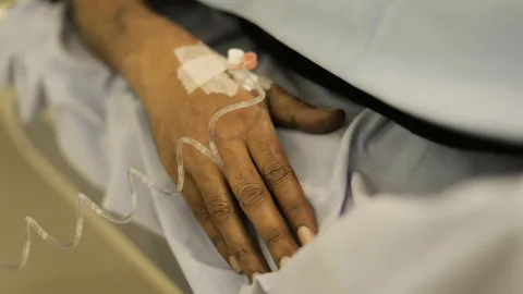 Close-up of a person's hand, receiving treatment intravenously.