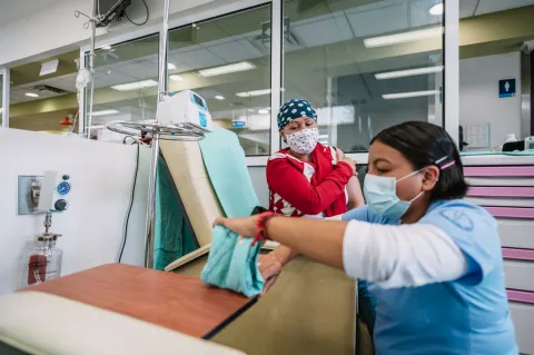 Cancer patient in hospital receiving treatment from a caregiver. Photo by Adán Jardón at INCAN, Mexico.