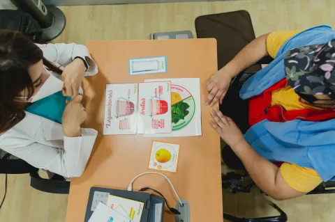 Solutions exist to detect breast cancer early in limited resource settings, despite significant challenges due to a lack of infrastructure, funding and trained healthcare professionals Doctor using a chart to explain healthy eating to a woman patient