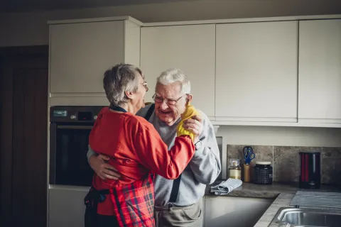Elderly Caucasian couple dancing in a kitchen