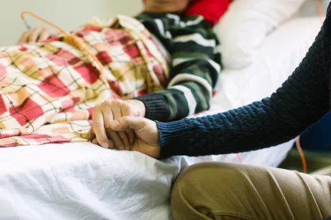 Patient and family member holding hands
