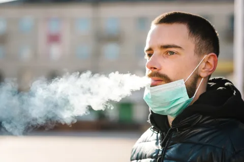 The tools exist to raise awareness about the risks of tobacco products, support people who wish to quit smoking, prevent others from starting, counter the influence of the tobacco industry and reduce the incidence of smoking and the diseases that tobacco Man smoking with medical mask on his chin
