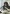 Woman with dark hair and glasses, smiling, is attended by a healthworker as she attempts to draw, while receiving IV treatment and a foot massage