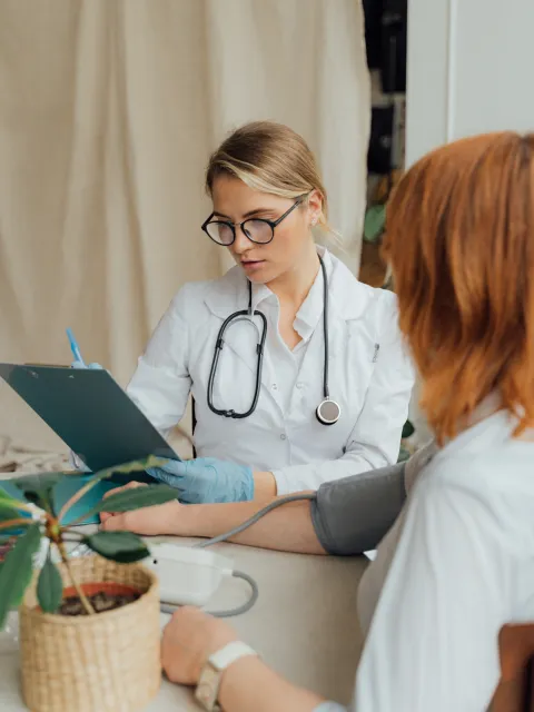 Woman having her blood pressure tested by a female doctor