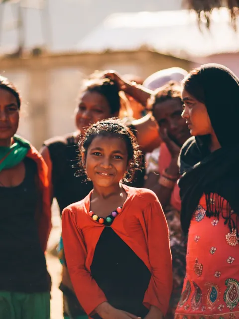 Group of Asian women of different ages, with young girl smiling at the camera