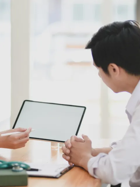 Asian man and woman healthworkers looking together at a patient file.