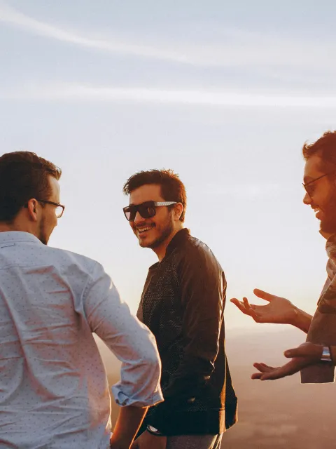 Three men talking together outside