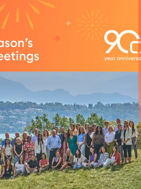 UICC branded Season's greeting card with UICC Geneva staff posing in front of the lake