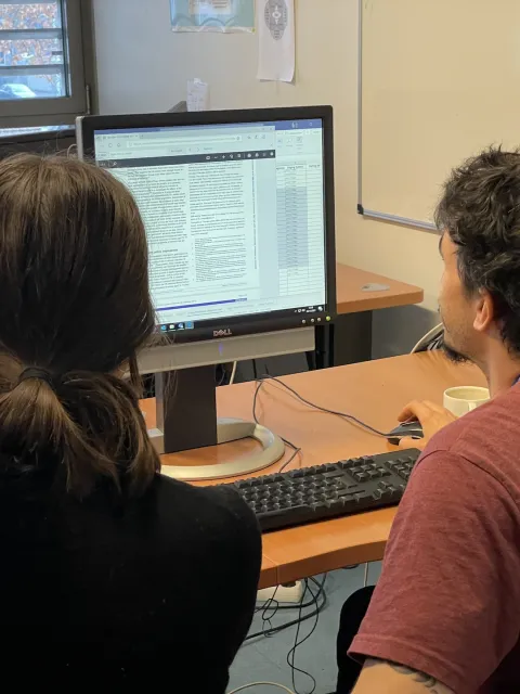 UICC Technical Fellow Javier David Benítez Fuentes with a woman colleague at IARC reading a report on a computer screen during his Fellowship at IARC