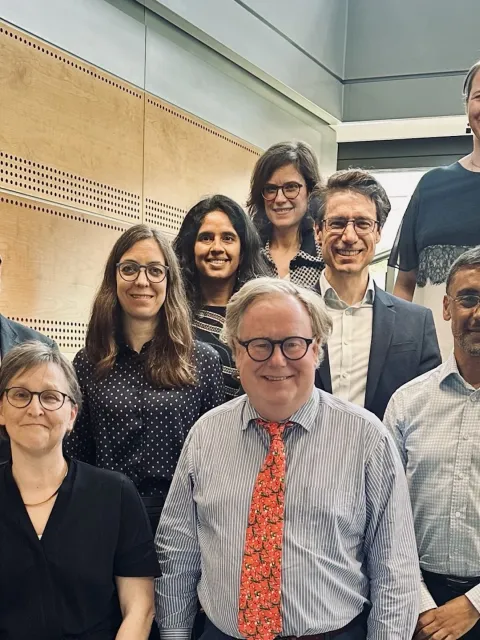 Diverse group of people standing in rows on a staircase, the TNM Core Committee