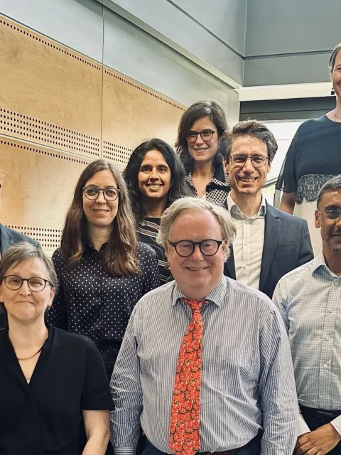 Diverse group of people standing in rows on a staircase, the TNM Core Committee