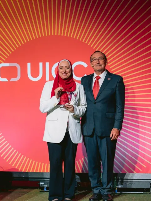 A photo of Hanaa Serry holding the World Cancer Day Award standing next to Jeff Dunn, UICC President at the World Cancer Congress 2024