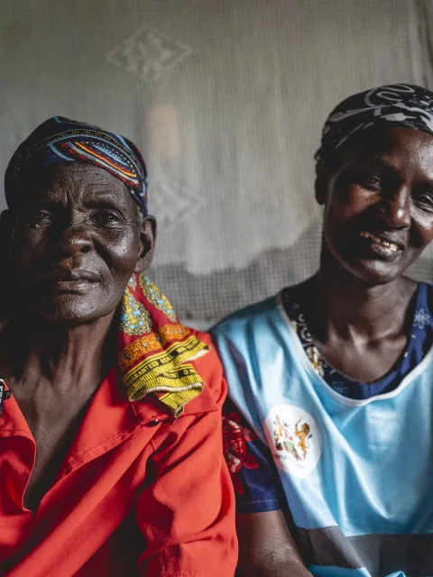 Two African women smiling into the camera, cut at chest.