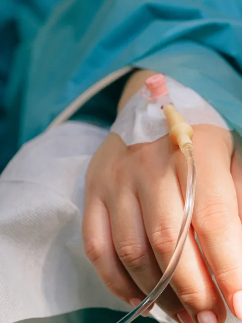 Close up of a hand of a hospital patient receiving IV antibiotics