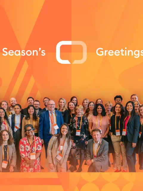 Season's greetings card from UICC, with staff photo against branded orange background