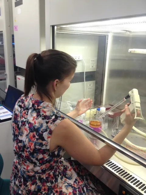 Woman in sleeveless flower dress checking lab equipment