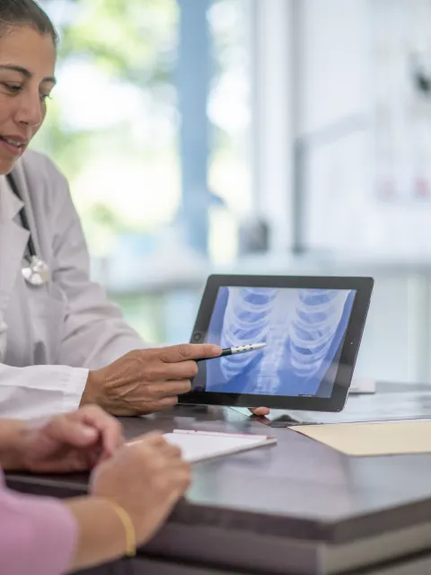 Female Hispanic doctor at an appointment with an older Hispanic woman.