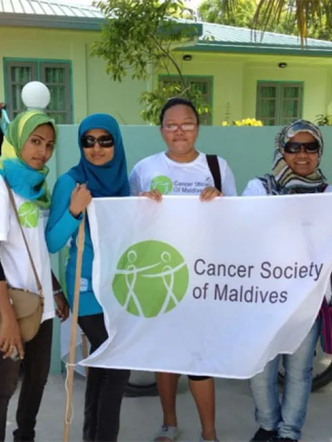 Volunteers of the Cancer Society of Maldives holdling up the organisation's banner