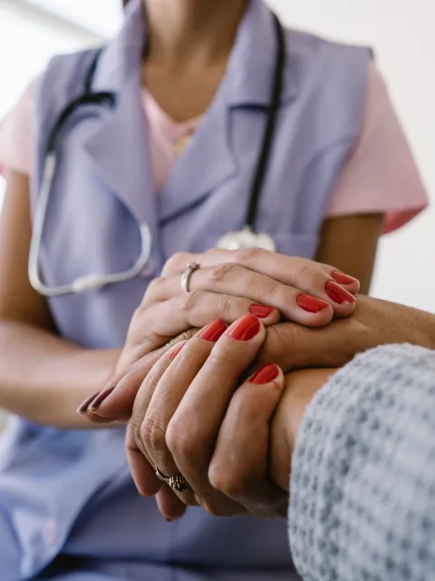 Nurse assisting a patient, close up of holding hands